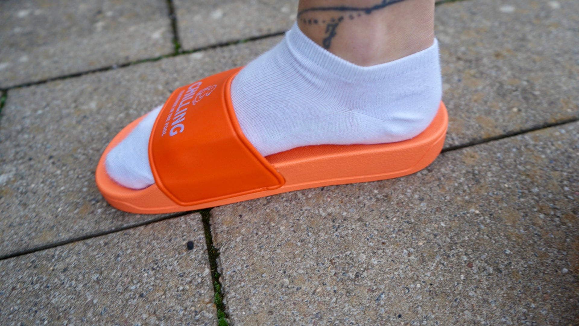 Hundebadelatschen Orange Fuß mit Tattoo
